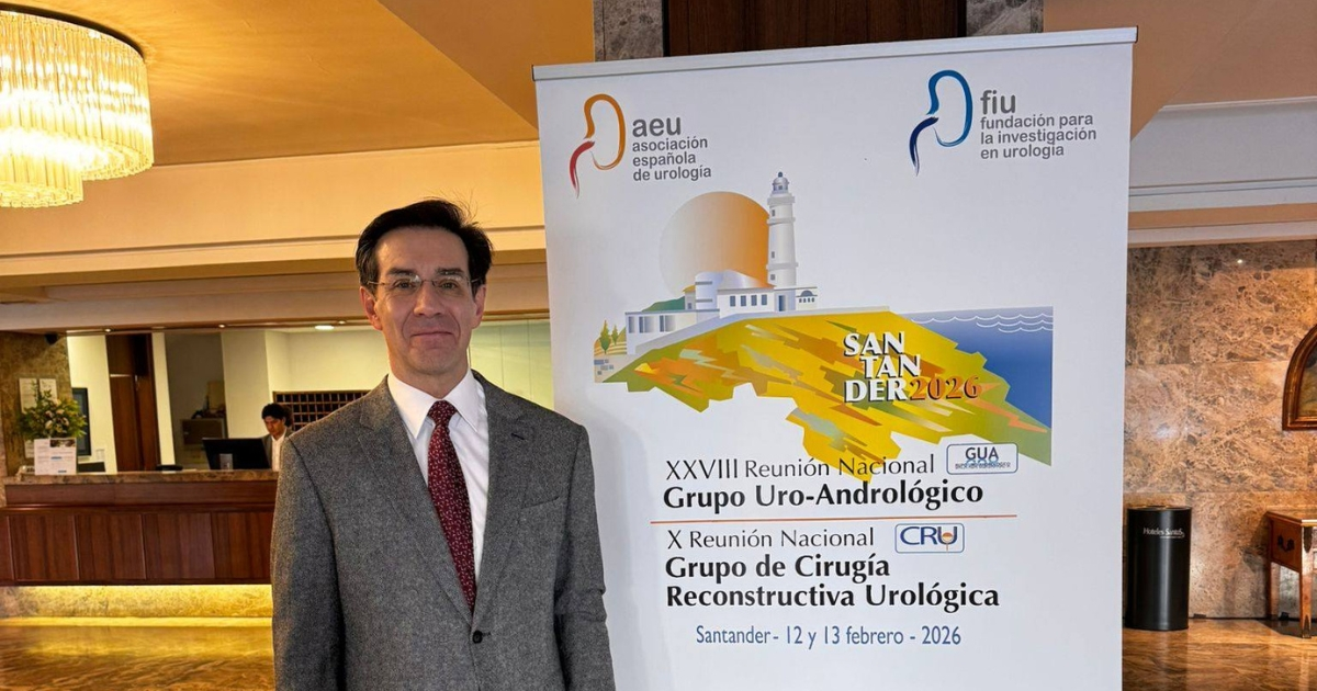 Doctor Peinado junto al poster de las Reuniones Nacionales del Grupo Uro-Andrológico